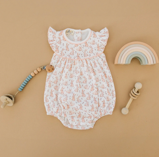 Baby wearing Luna & Arlo Bunny Patch Flutters Bubble romper in sweet pink with ruffled sleeves and pink bunny print, ideal Easter outfit for newborns and infants.