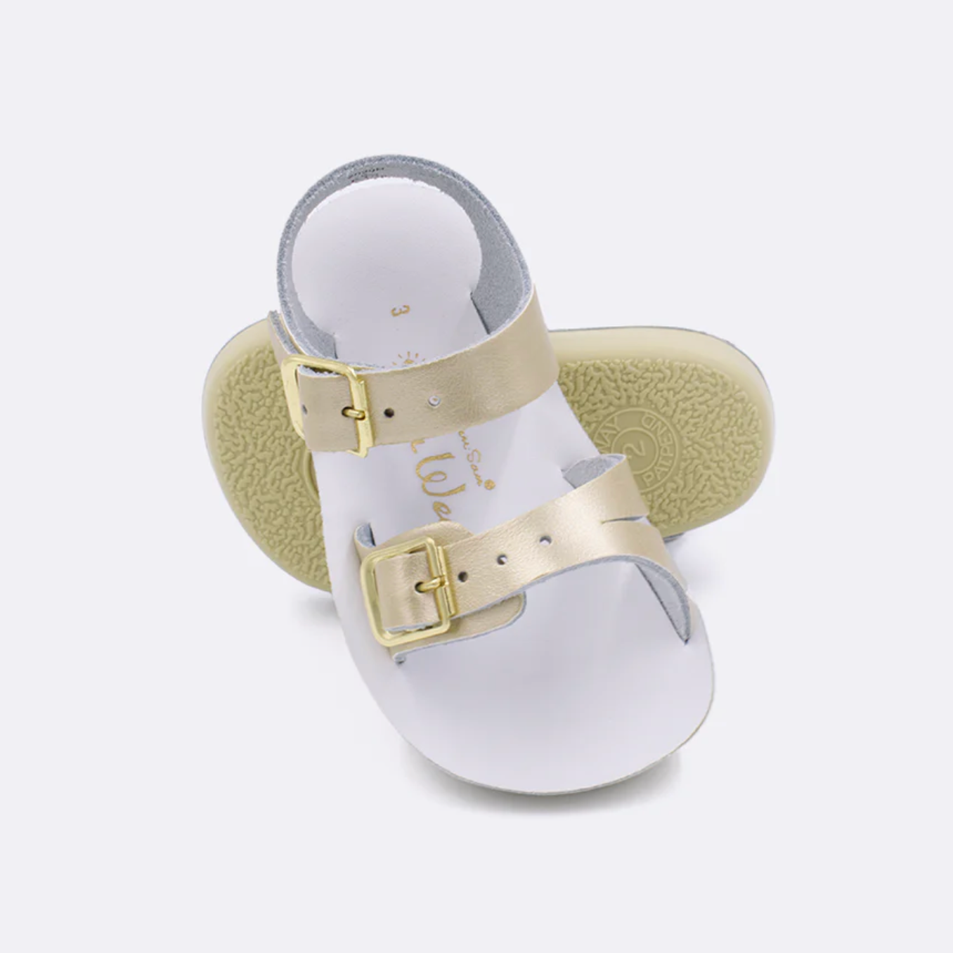 Infant gold leather sandal with adjustable buckles and flexible sole, water-friendly and soft for baby’s first steps.